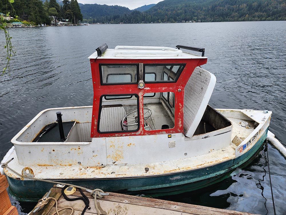 A small red and white boat is docked in the water.