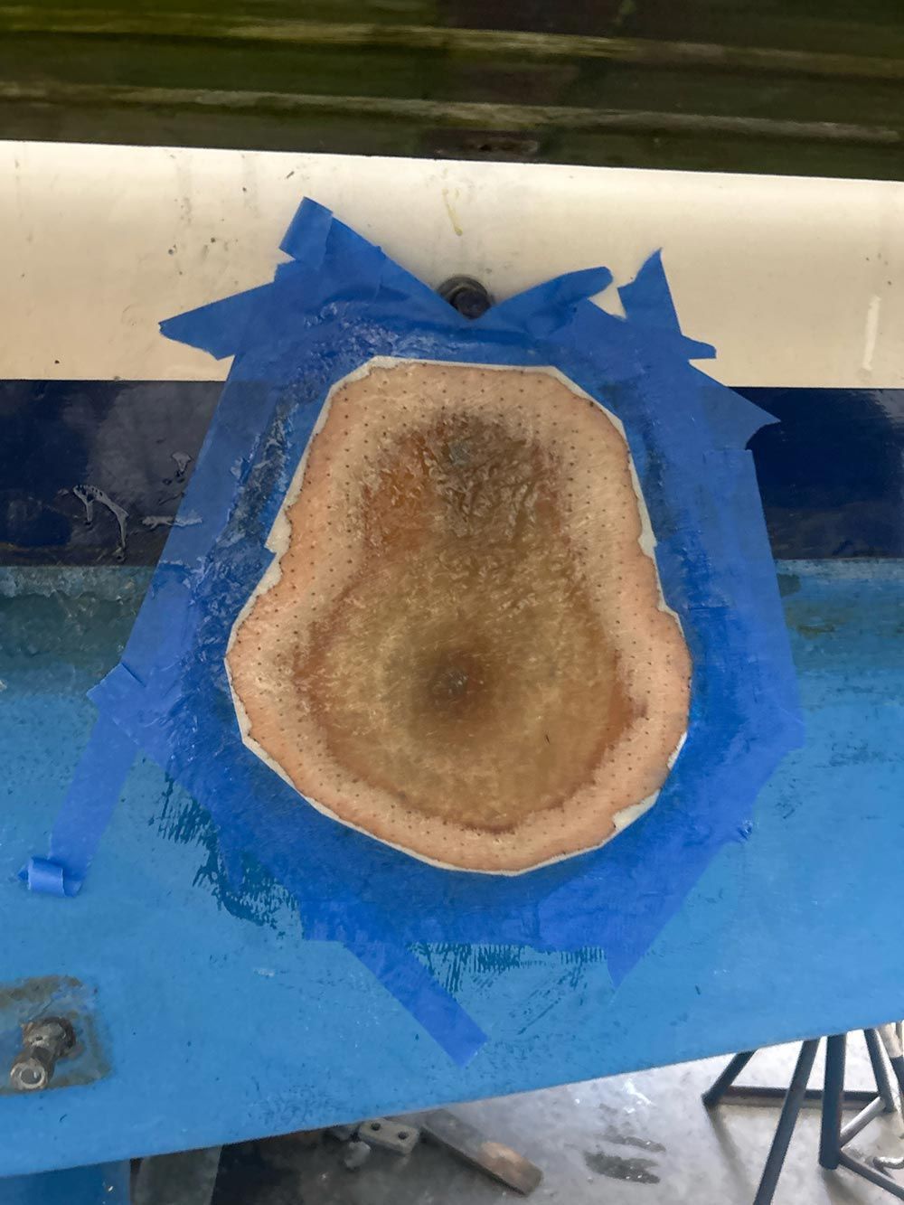 A piece of wood is sitting on top of a blue table.