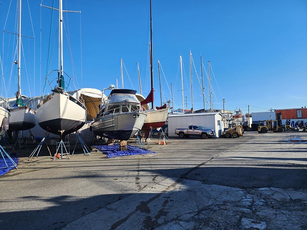 A row of boats are docked in a marina on a sunny day.