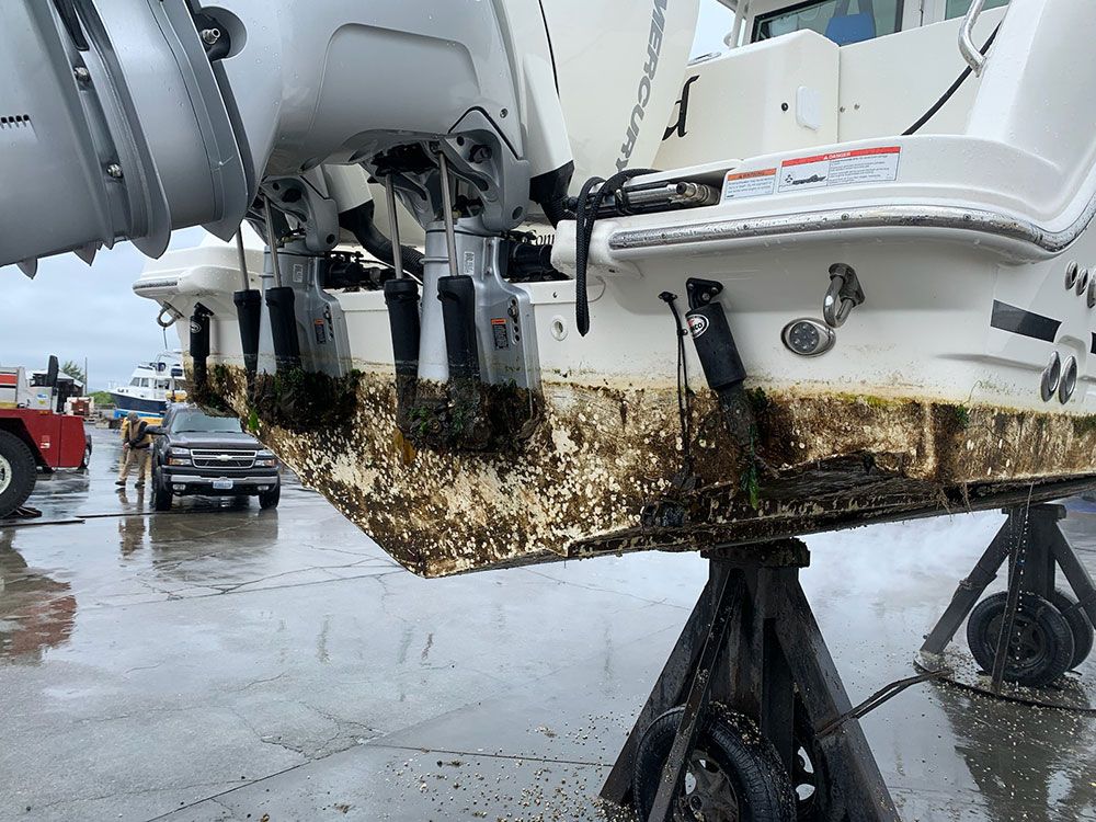 A boat is sitting on a wooden stand in the rain.