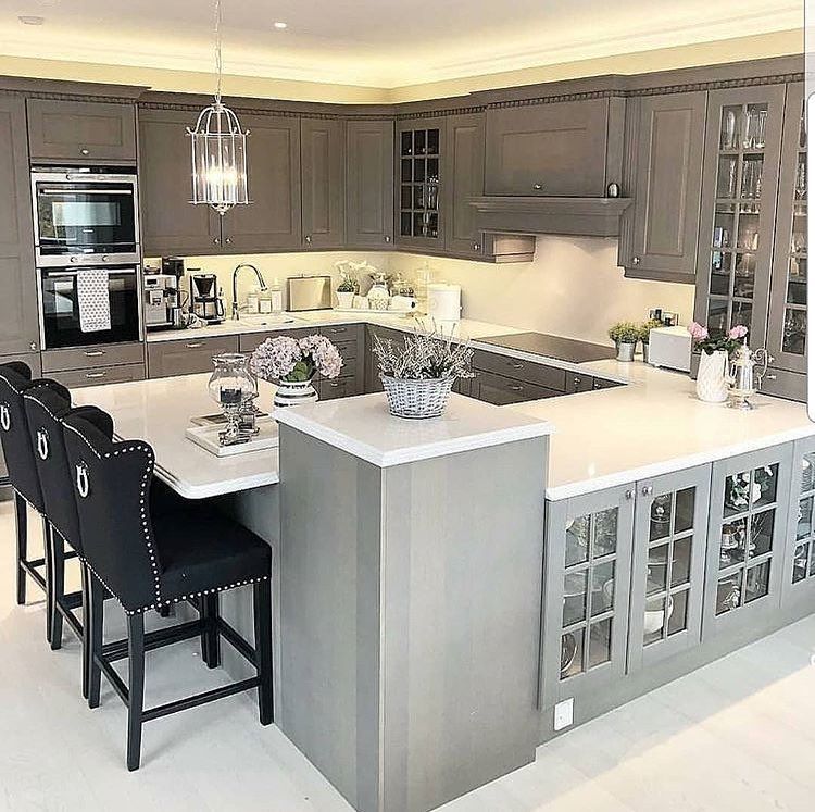 Gray kitchen with a large island and bar seating. Cabinets, countertops, and appliances are visible.