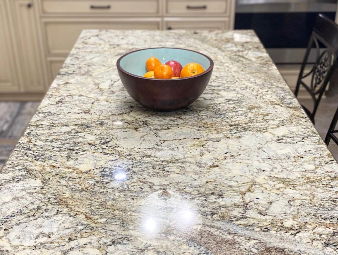 Bowl of fruit on a granite countertop in a kitchen.