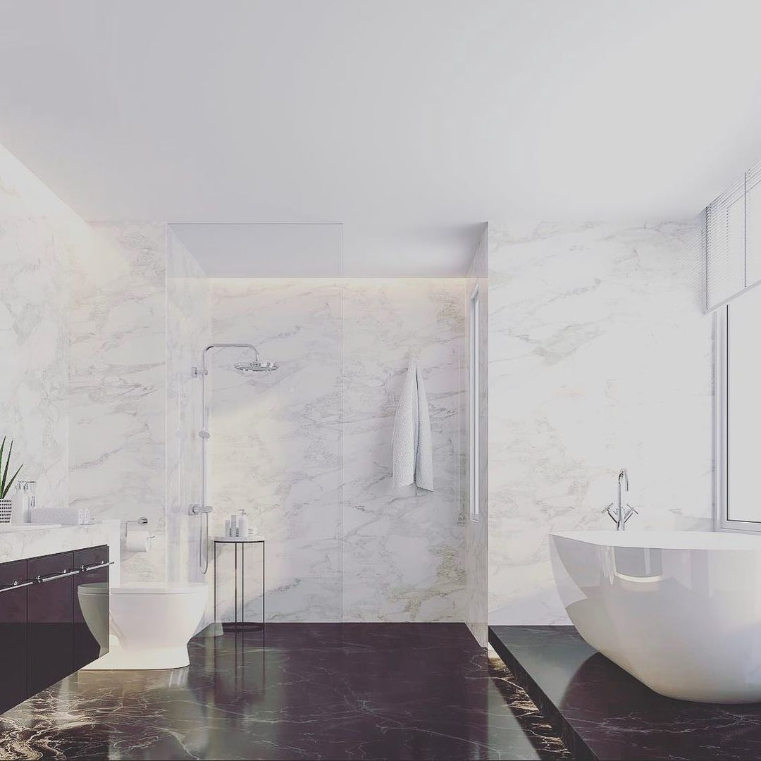 Elegant bathroom with marble walls and dark flooring; a tub, shower, and toilet are visible.