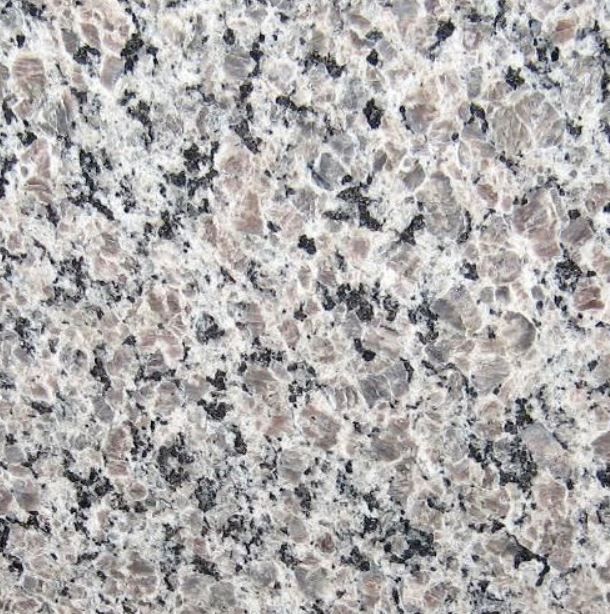 Close-up of granite surface with gray, black, and brown speckled patterns.