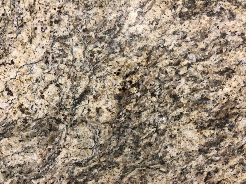 Close-up of granite with tan, black, and gray swirls and speckles.
