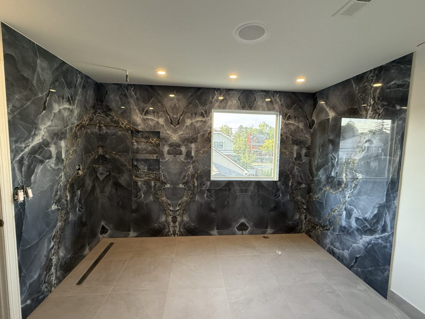 Empty modern room with dark marble walls and a framed map centered on the back wall.