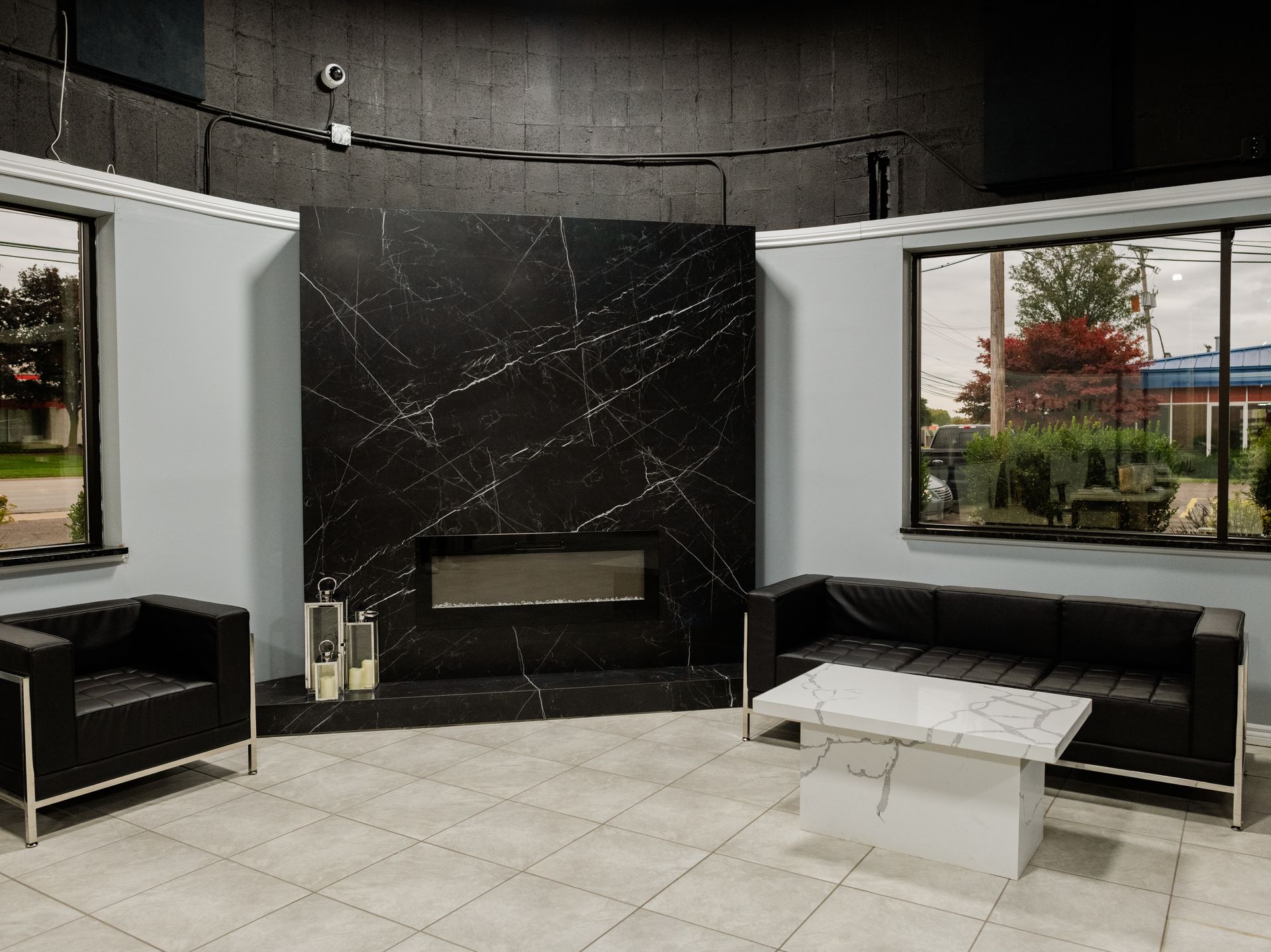 Waiting area with black marble fireplace and two couches