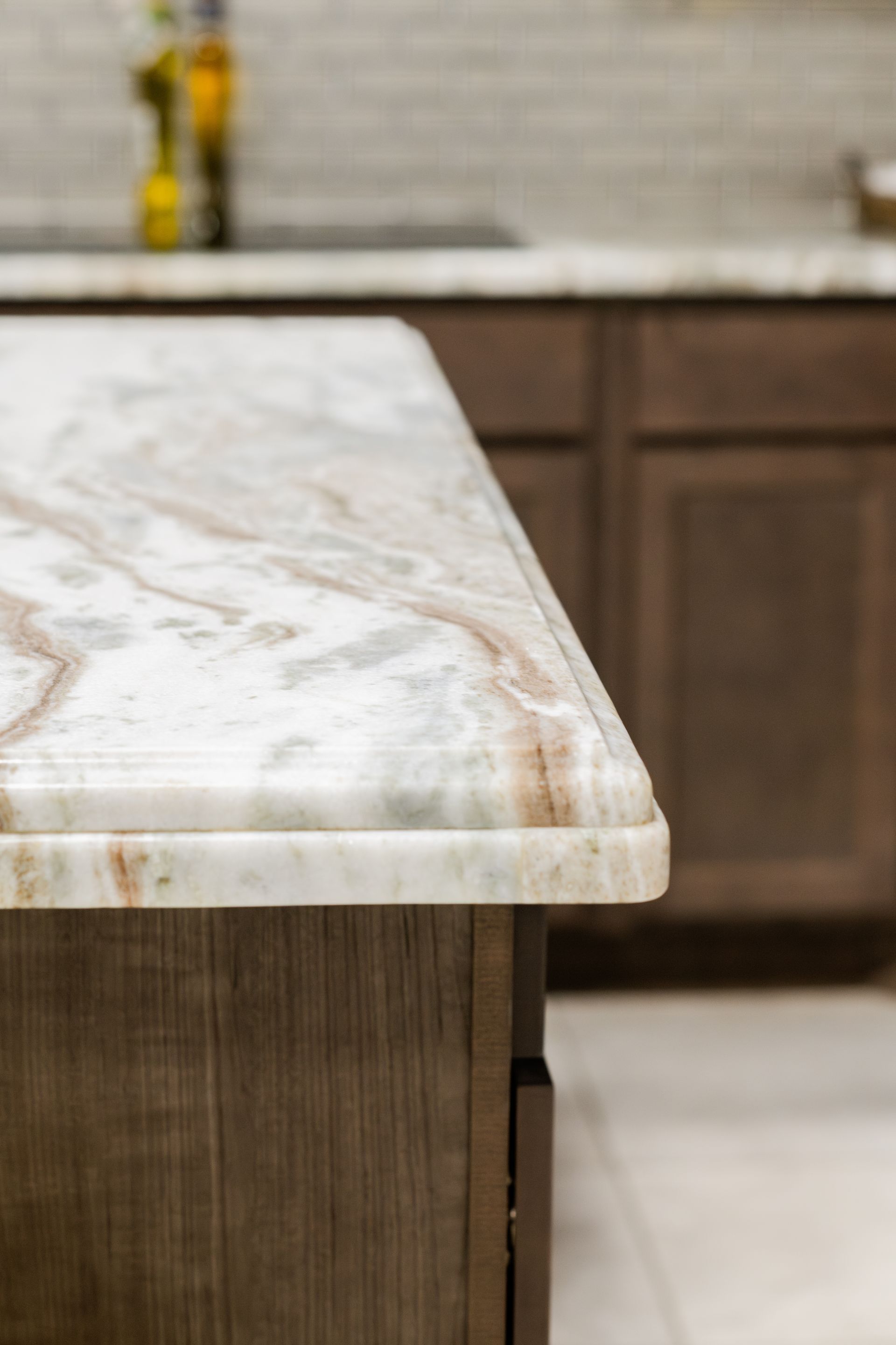 Marble countertop edge in a modern kitchen with wood cabinets in the background