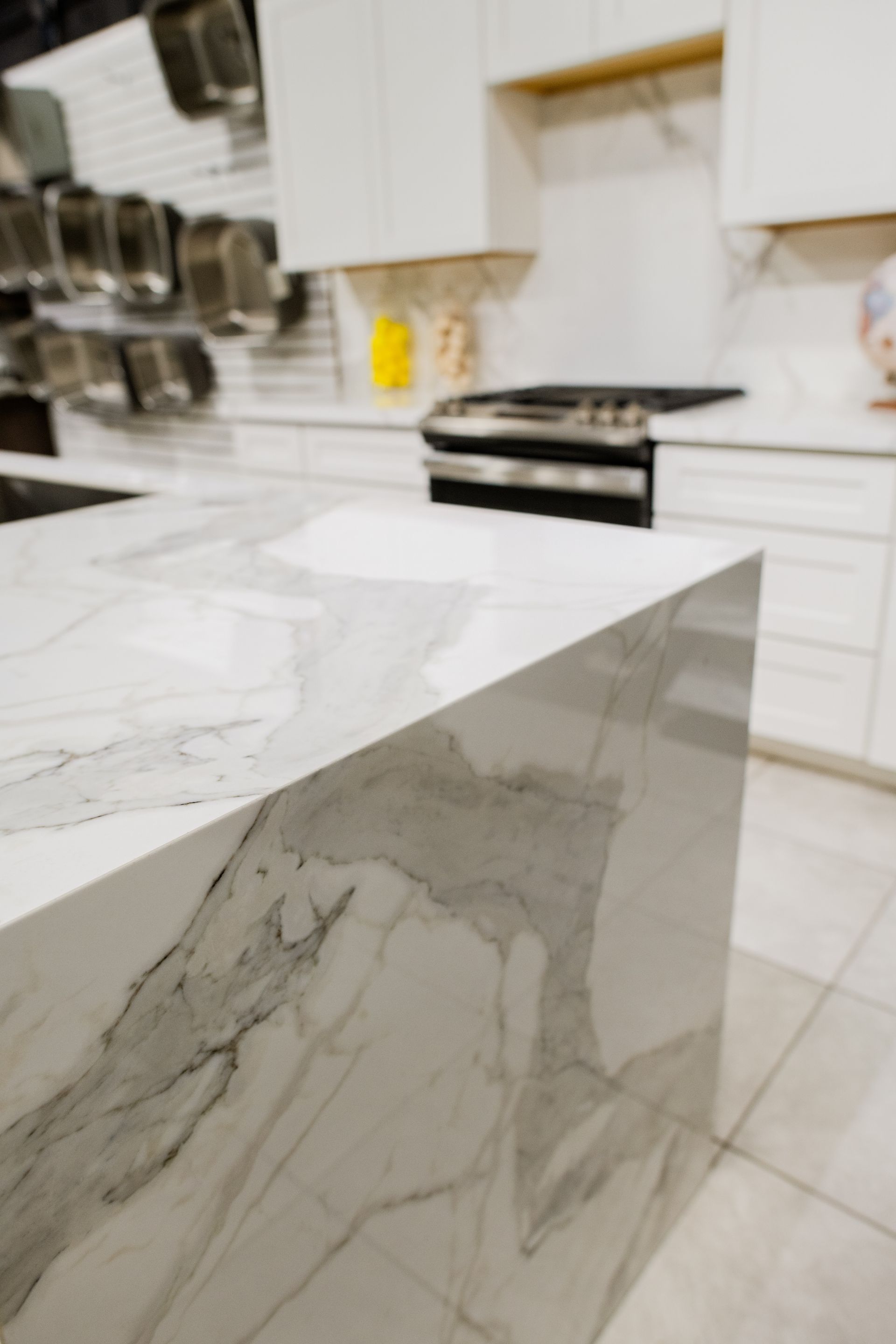 Marble kitchen island countertop with white cabinets and stove in a modern kitchen