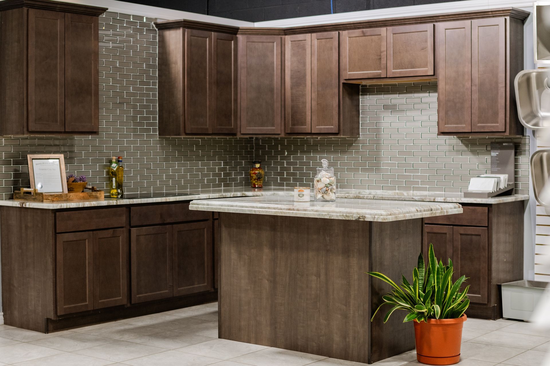 Modern kitchen with dark wood cabinets, granite island, and tiled backsplash