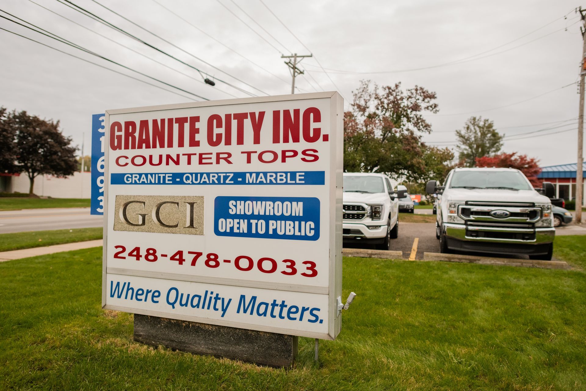 Granite City Inc's sign in front of a truck on a grassy roadside