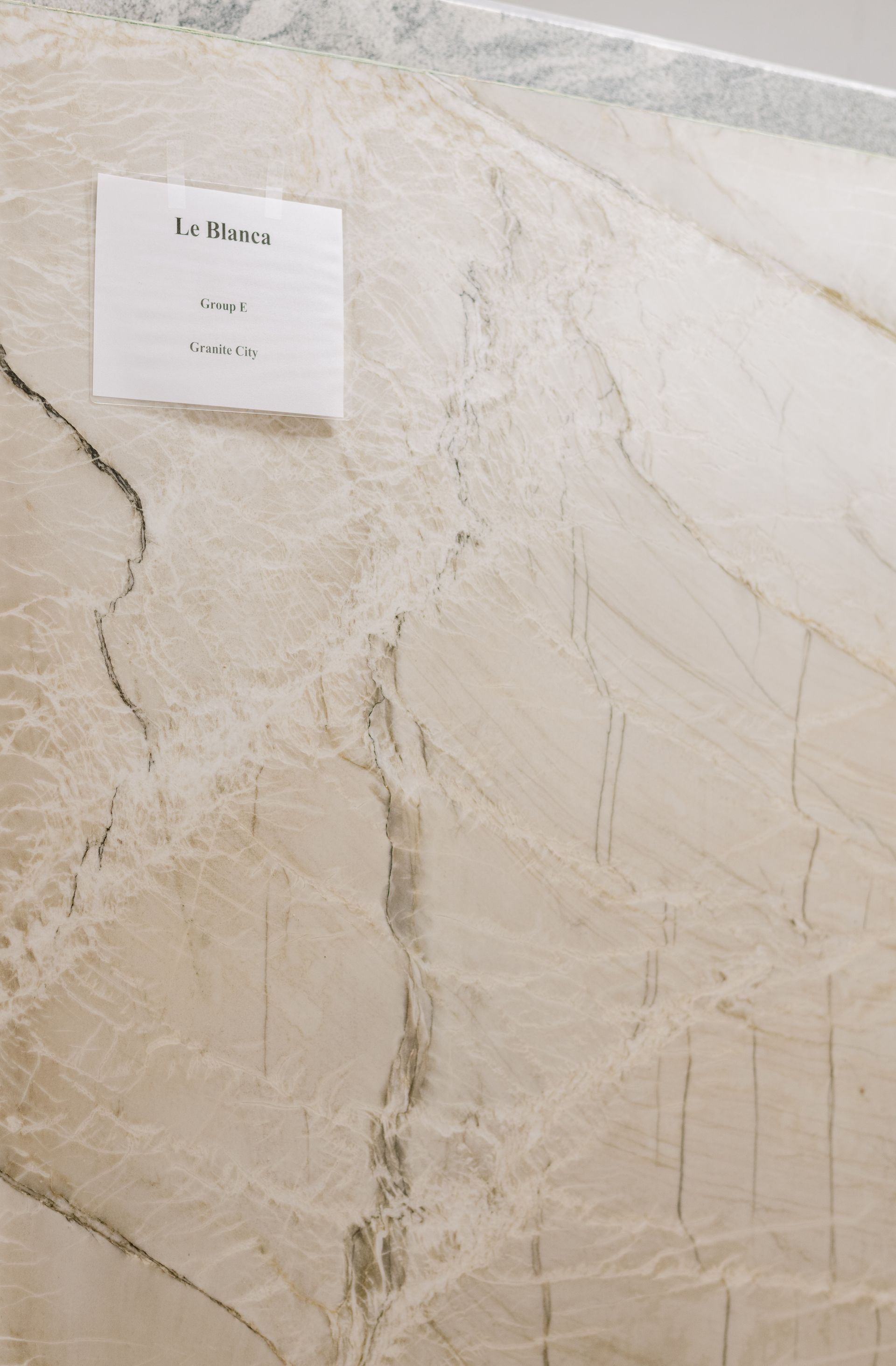 Small white sign on a beige marble wall
