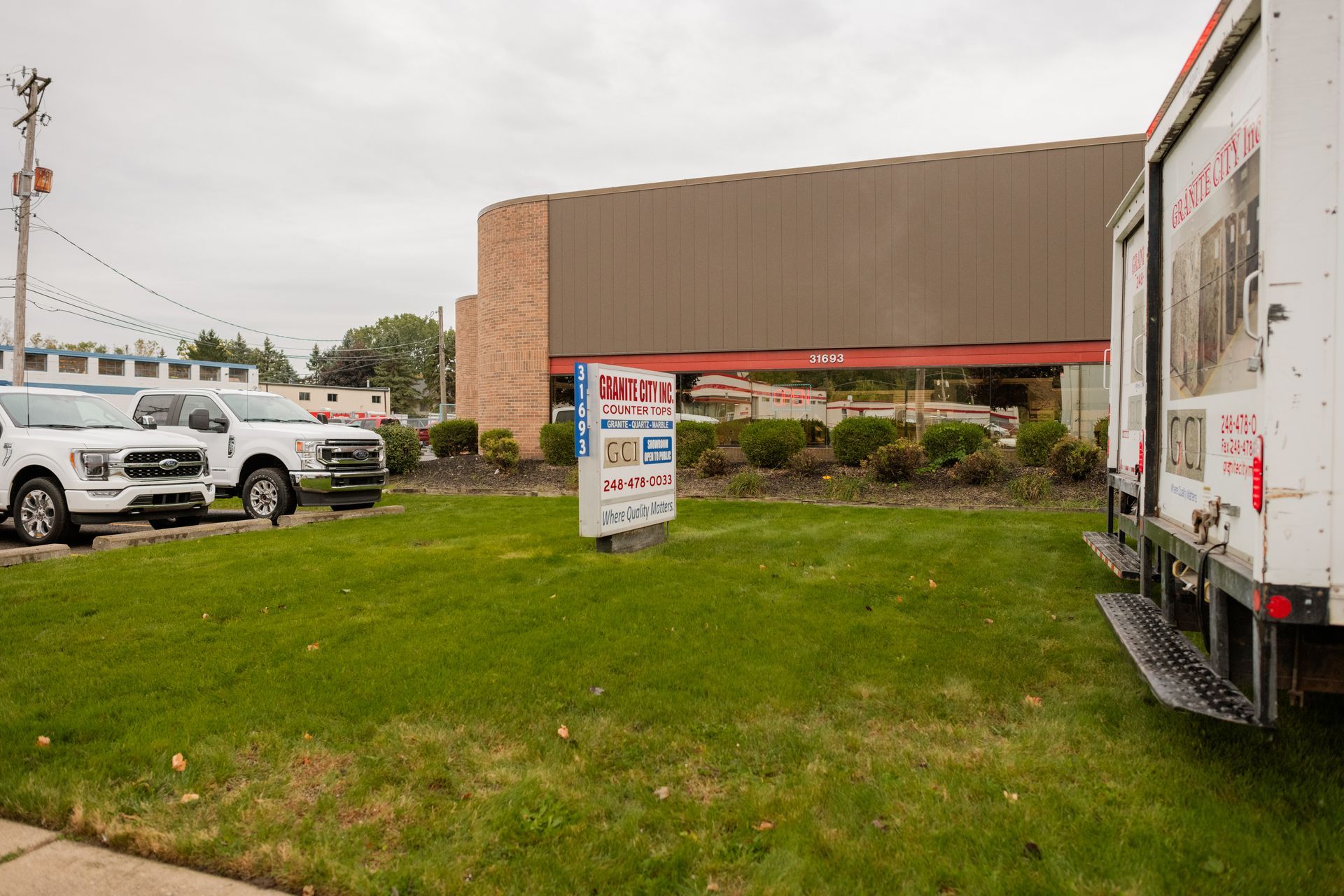 Building parking lot with grass and parked trucks