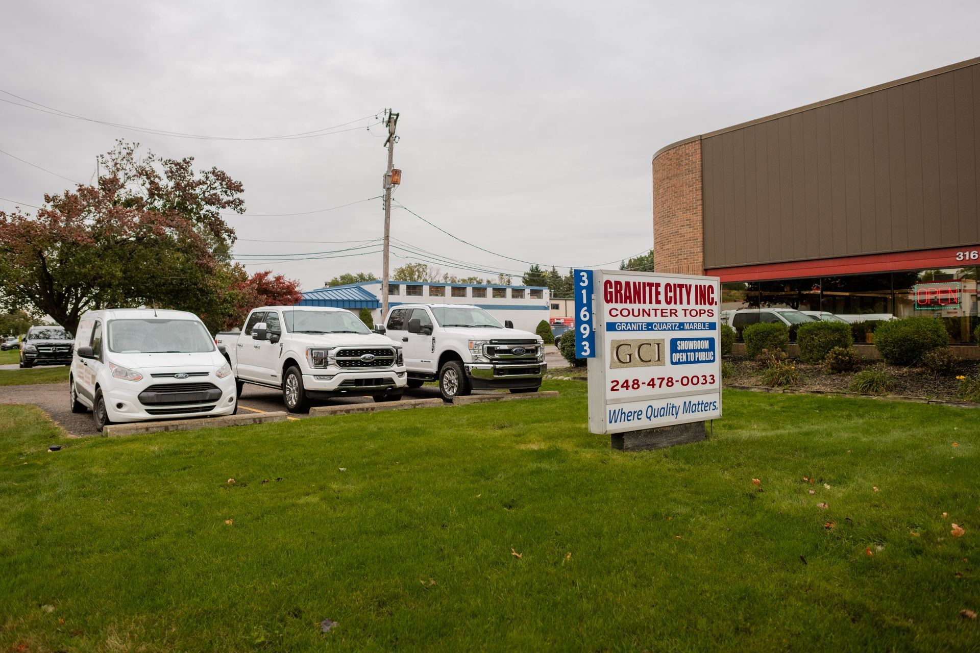 White vehicles parked on a grassy lot 