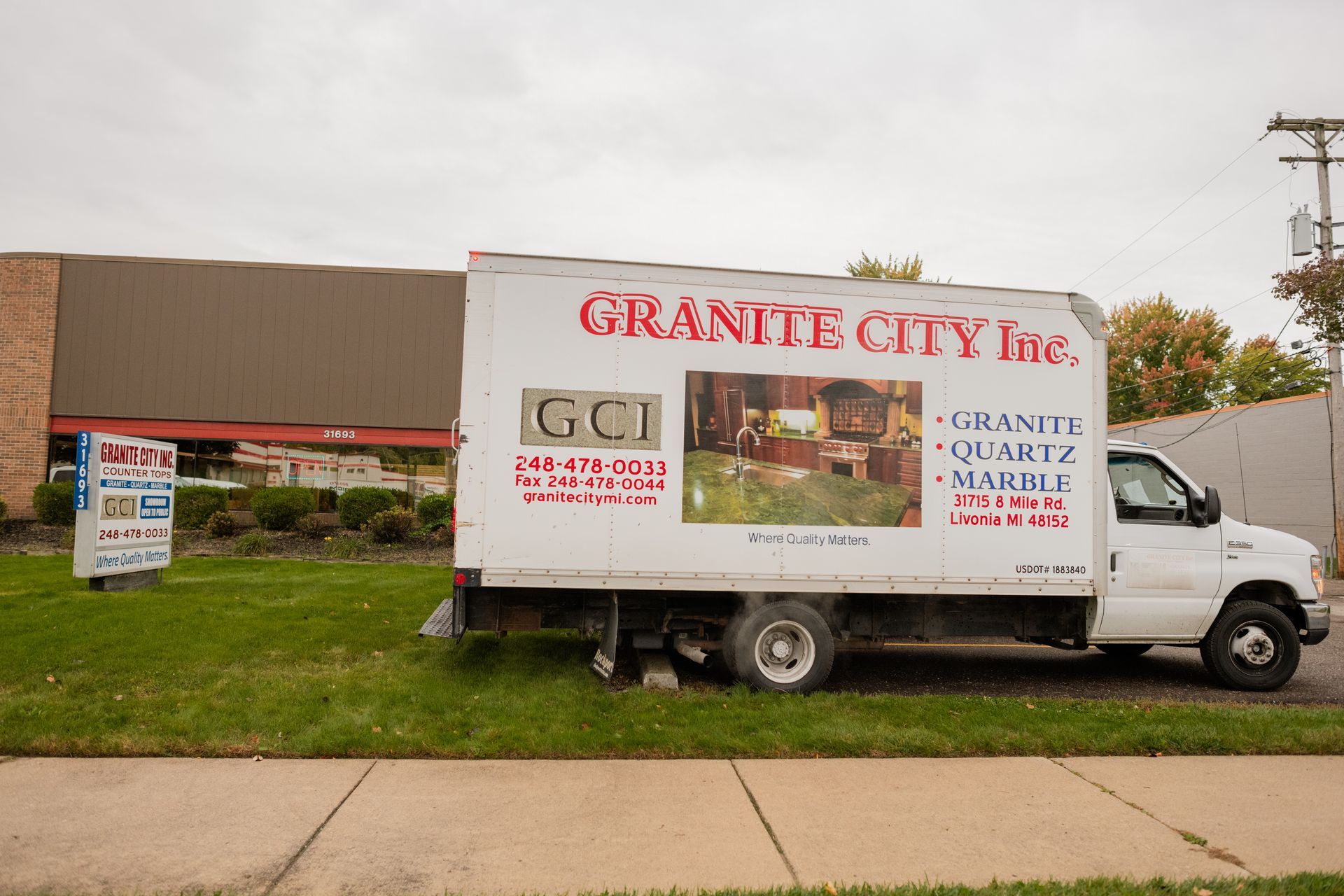 Granite City Inc's white truck parked outside a building