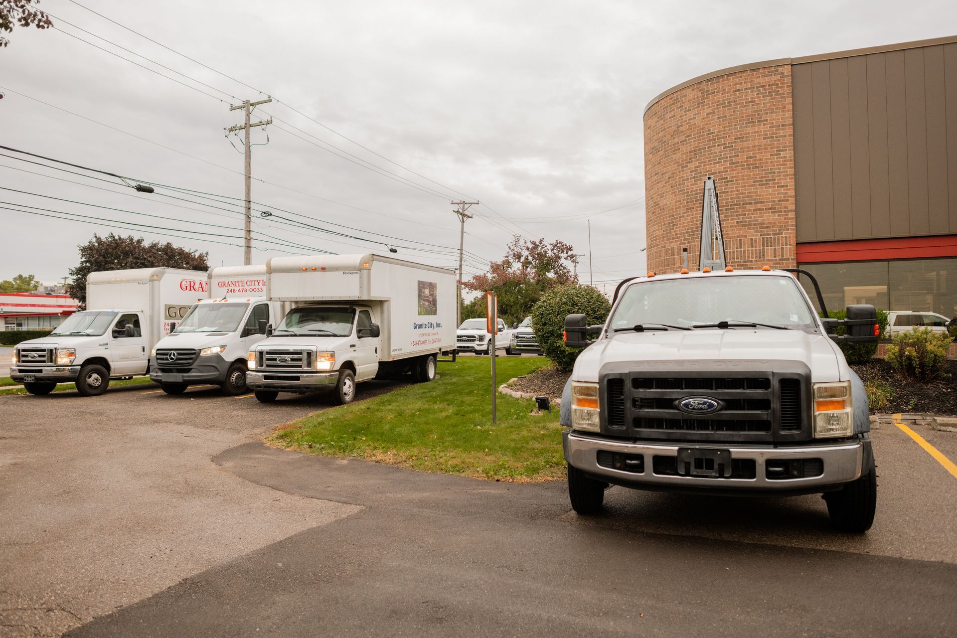 Trucks parked outside a building on a cloudy day