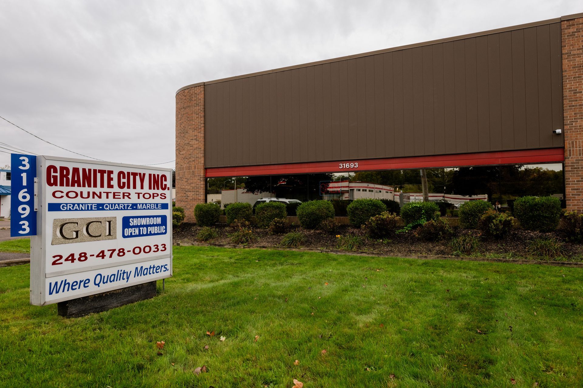 Granite City Inc's sign beside a large brown building and grassy lot