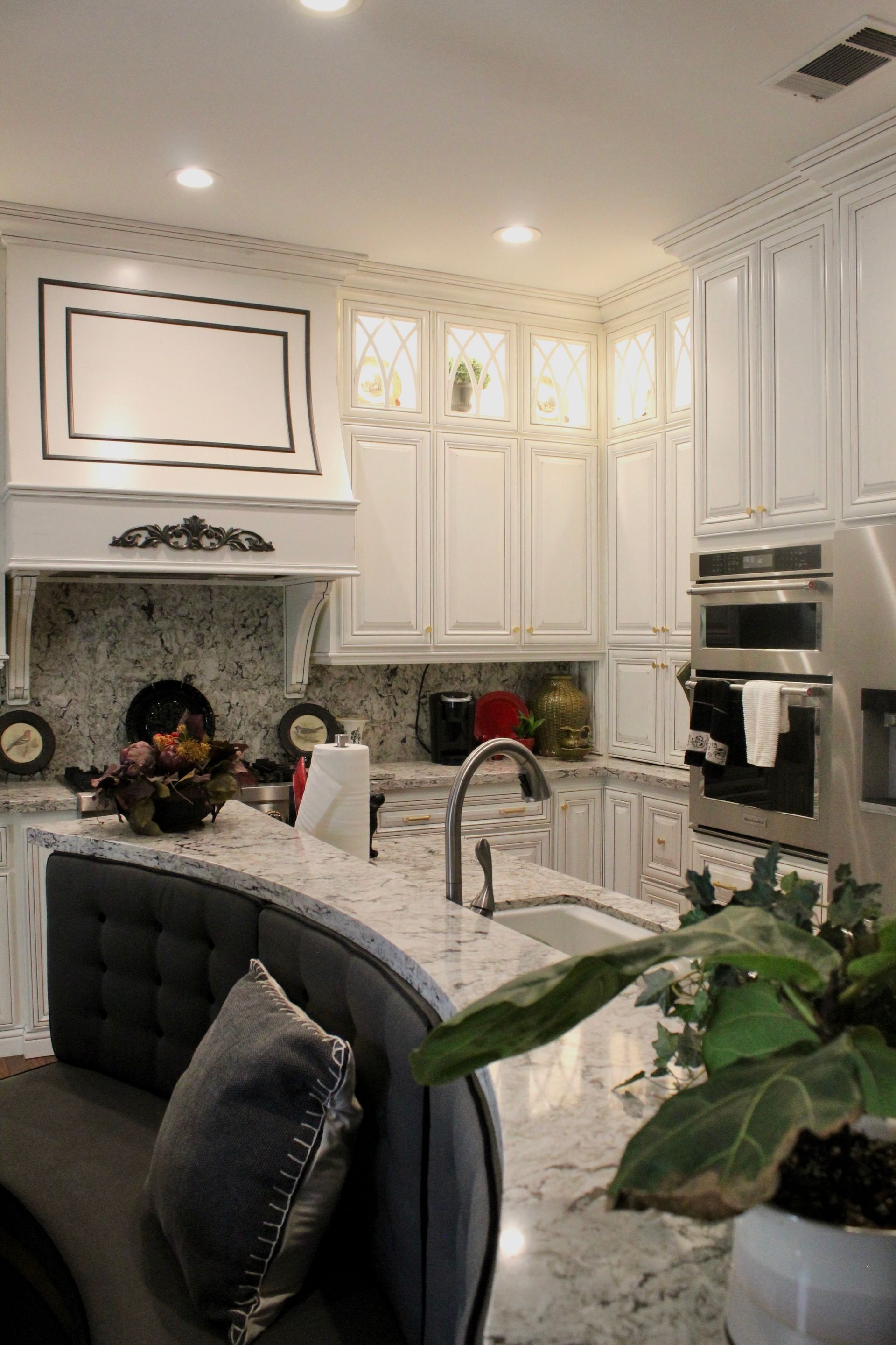 A kitchen with white cabinets , granite counter tops , and stainless steel appliances.