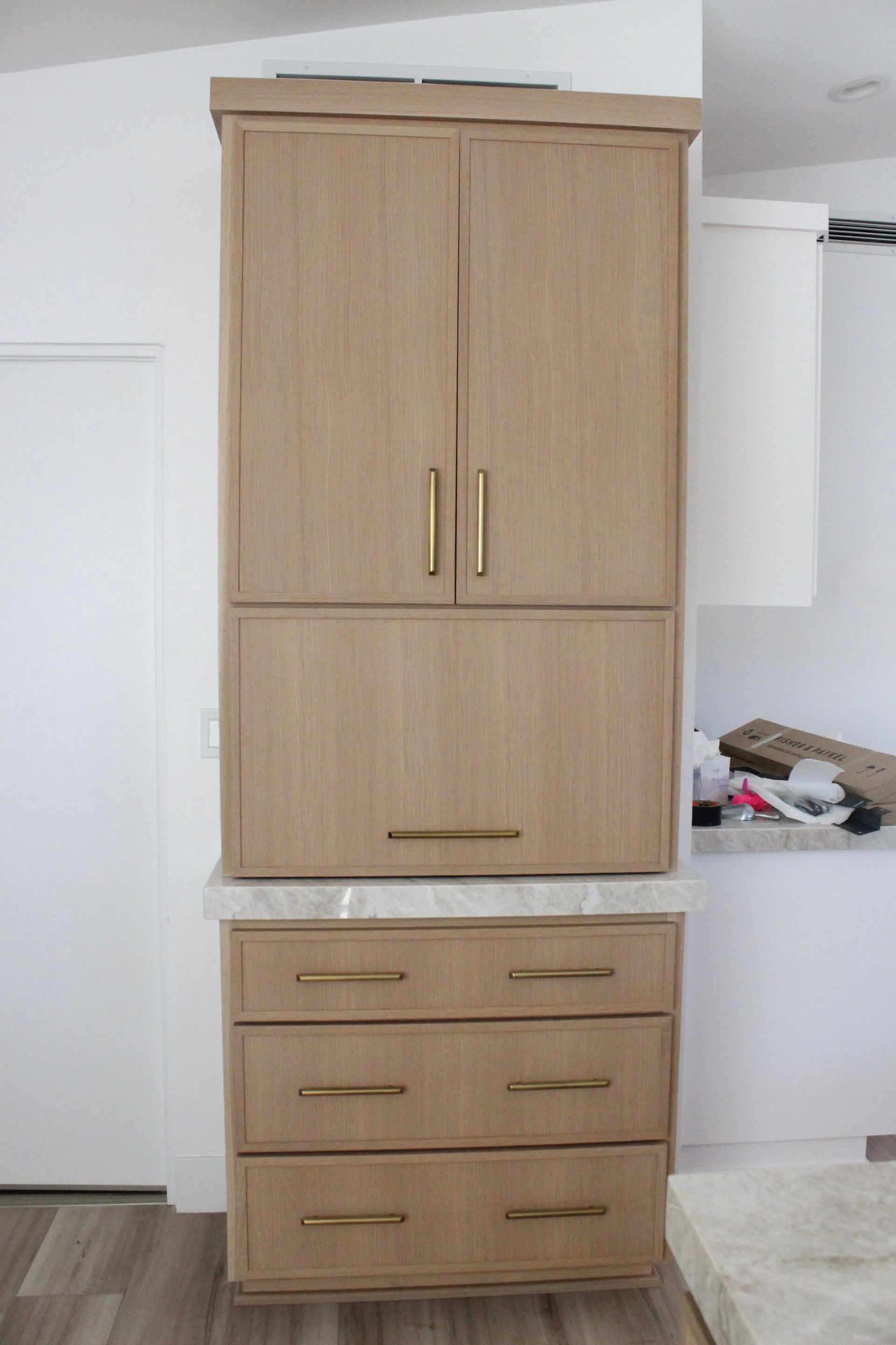A wooden cabinet with drawers and doors in a kitchen.
