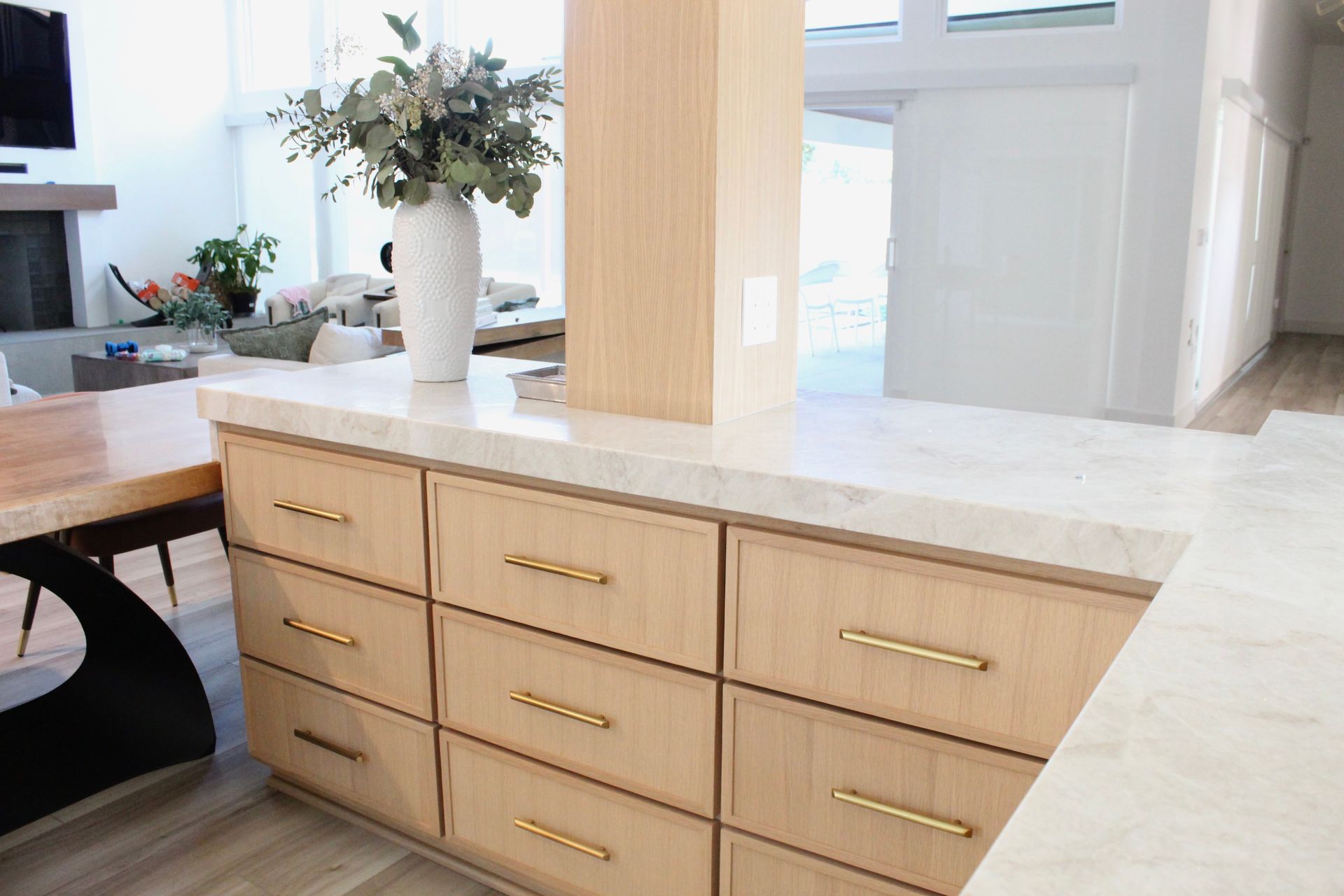 A kitchen with wooden cabinets and a marble counter top.