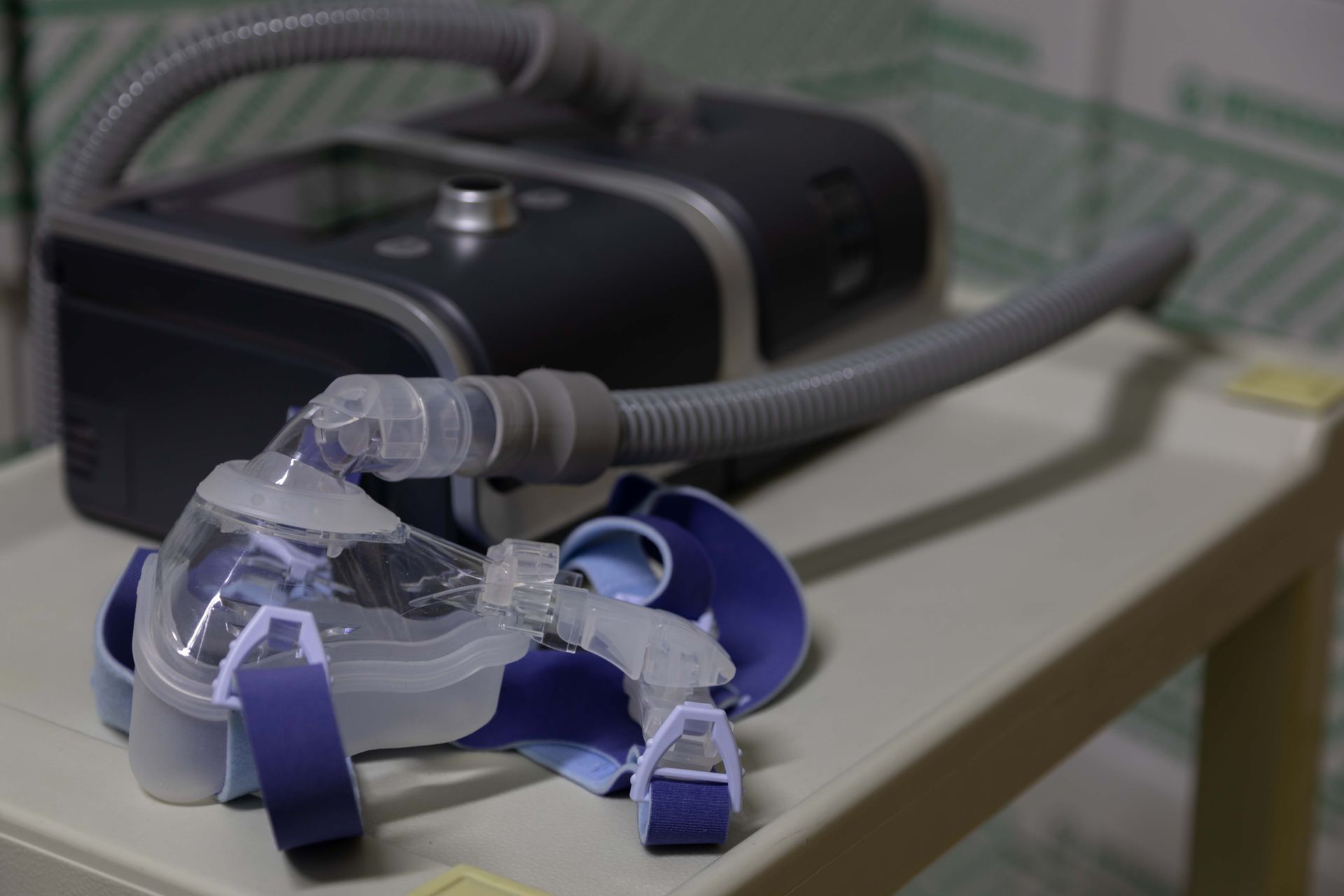 Nebulizer with blue face mask emitting steam on a table in a home setting