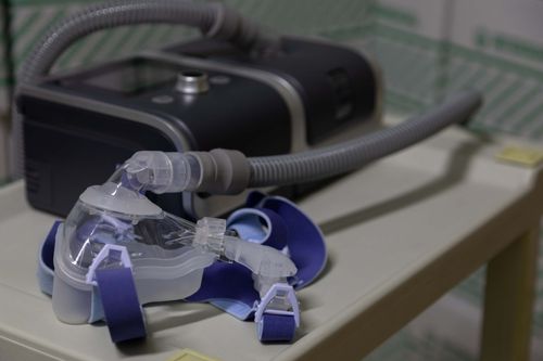Nebulizer with clear mask emitting steam on a table in a soft-lit room