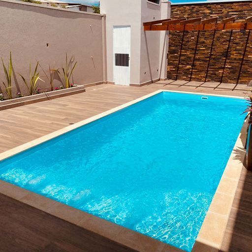 A large swimming pool with a stone wall in the background