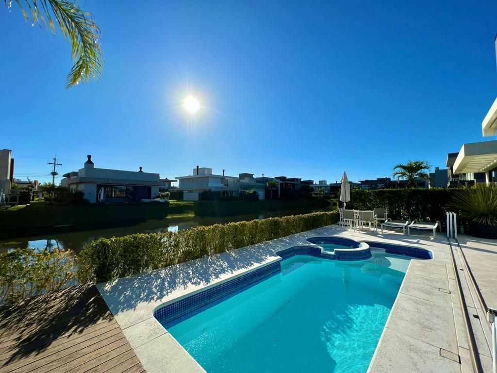 There is a large swimming pool in the backyard of a house.