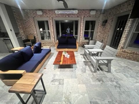 A living room with a couch , chairs , and a coffee table.