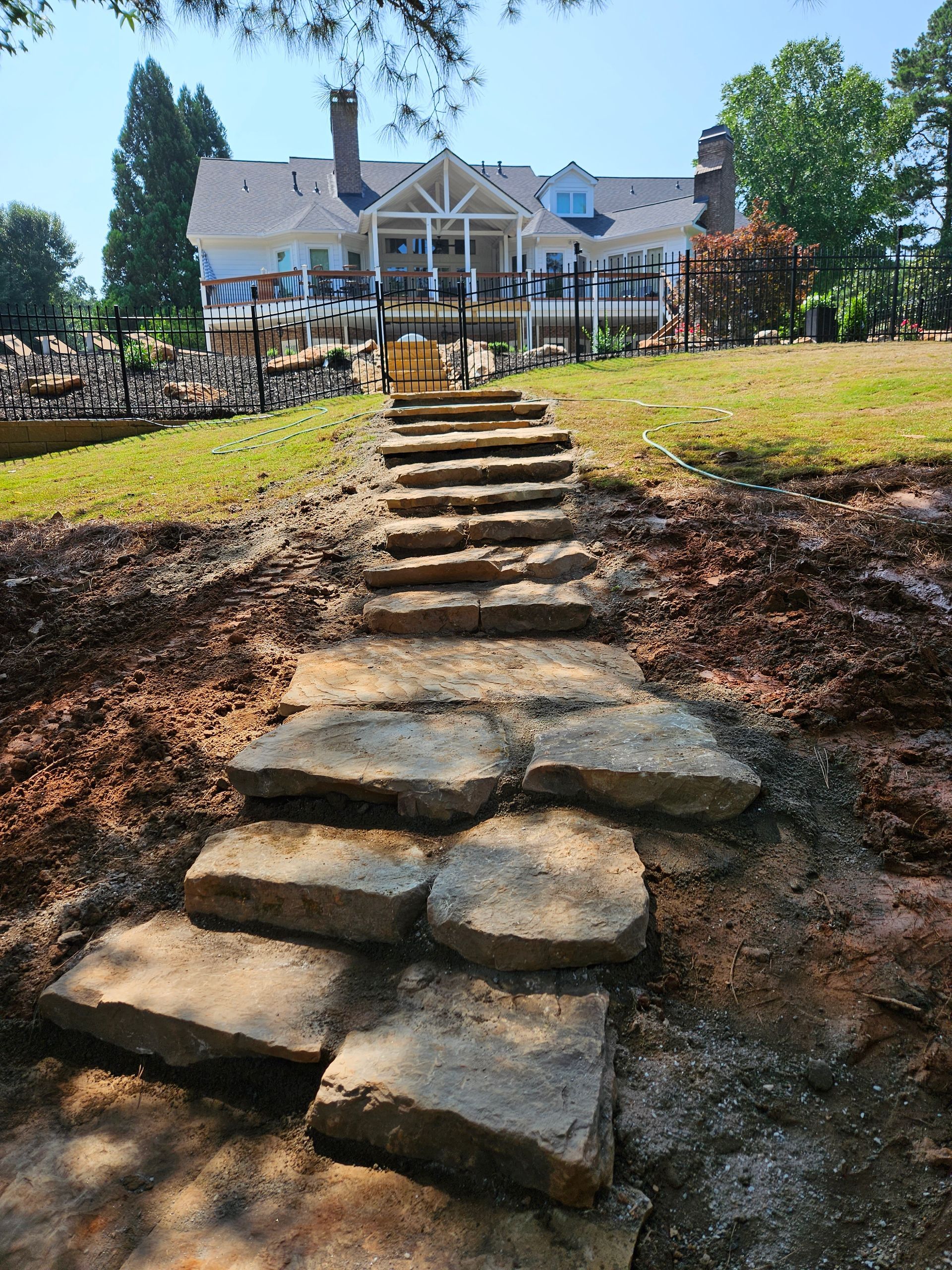 A stone walkway leading to a large house