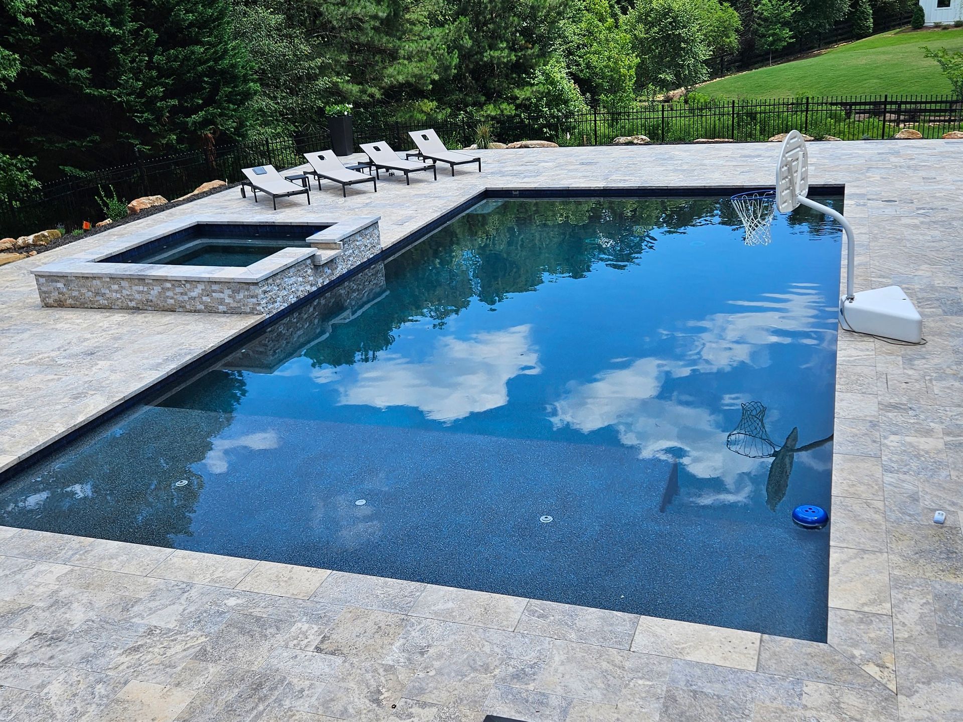 A large swimming pool surrounded by chairs and trees