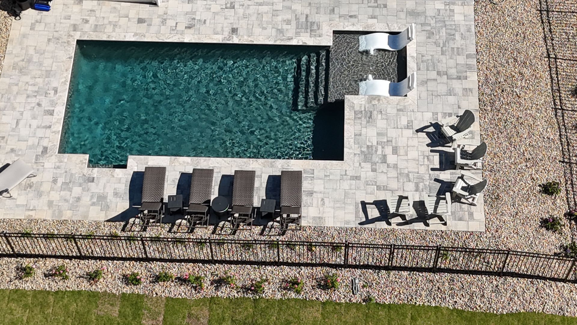 An aerial view of a large swimming pool with chairs and a slide.
