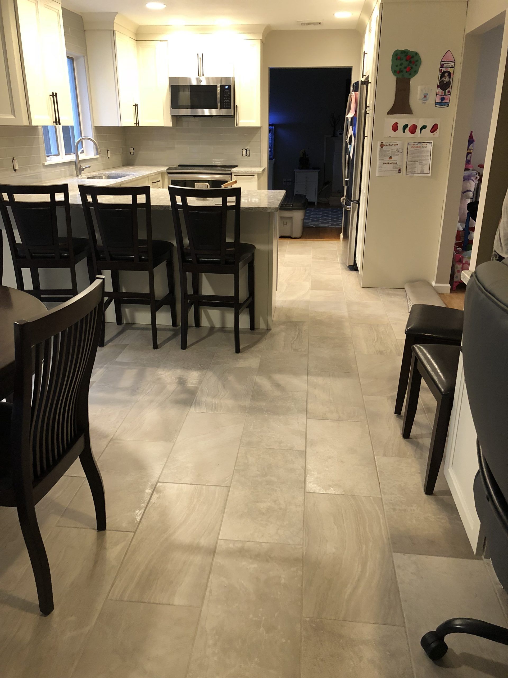 Open kitchen and dining area with bar stools, tiled floor, and recessed lighting