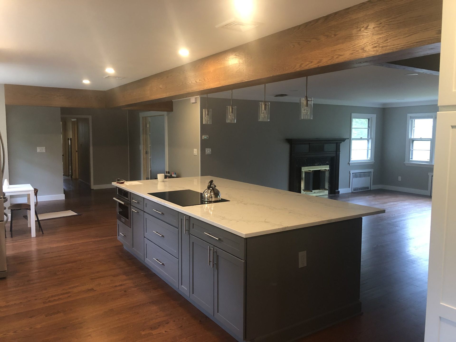Open kitchen with large island, dark cabinets, hardwood floors, and recessed lighting in a spacious room