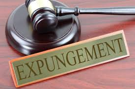 Gavel on wooden block beside a sign that reads EXPUNGEMENT.