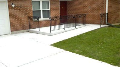 A brick house with a ramp leading to the front door.
