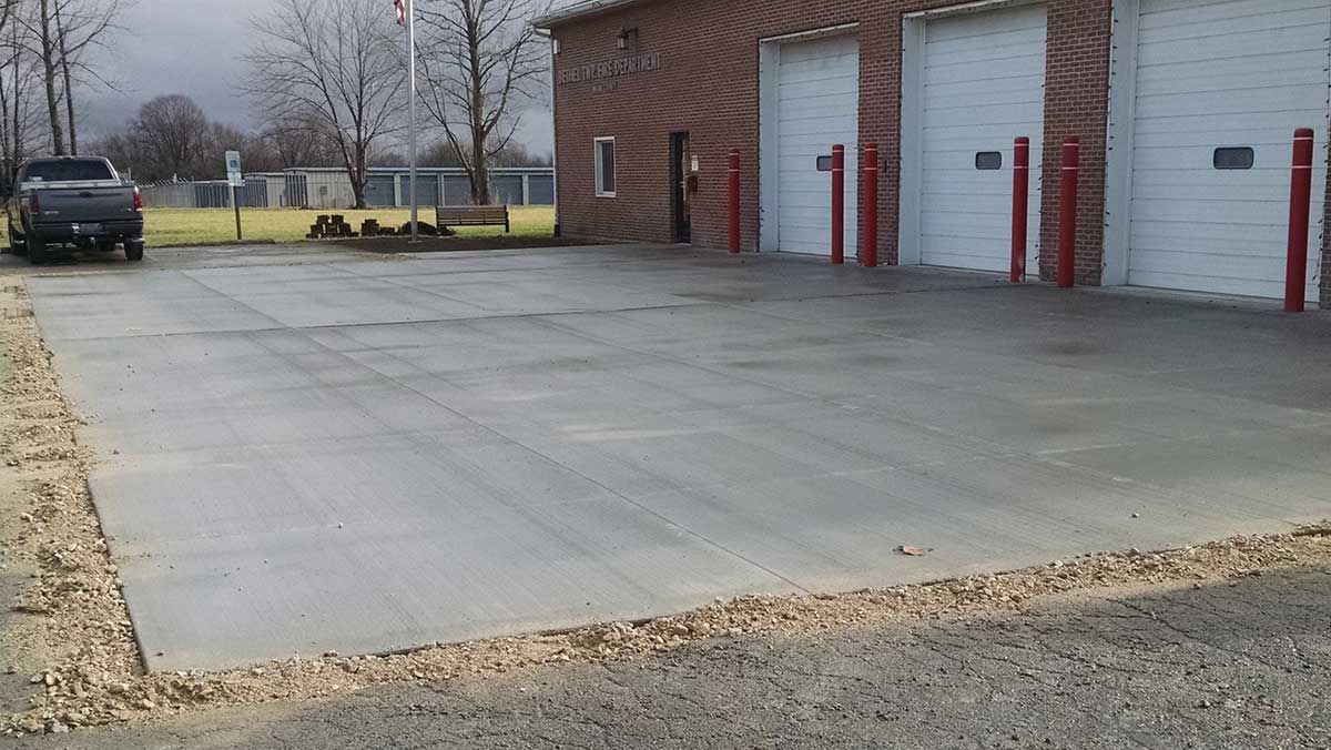 A truck is parked in a parking lot in front of a garage.