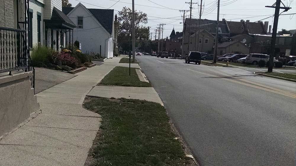 A street with a sidewalk and houses on both sides of it