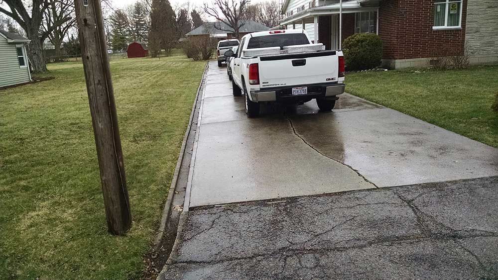 A white truck is parked in the driveway of a house.