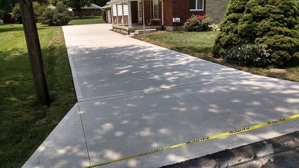 A concrete driveway is being built in front of a house.