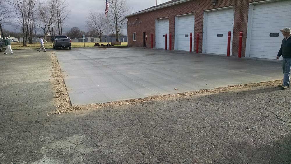 A man is standing in front of a building with a lot of garage doors