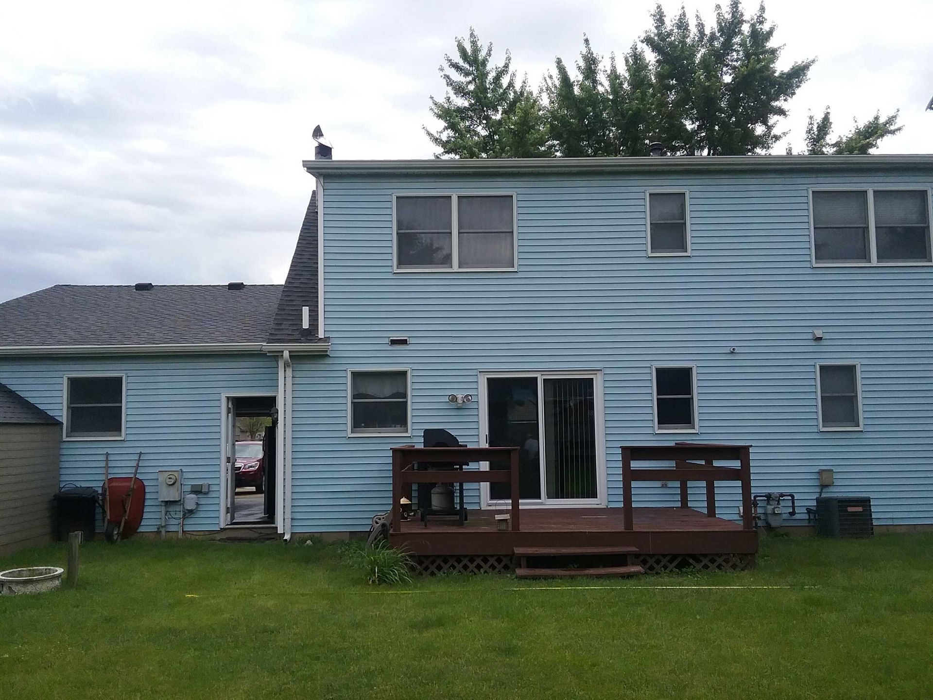 A blue house with a deck in the backyard