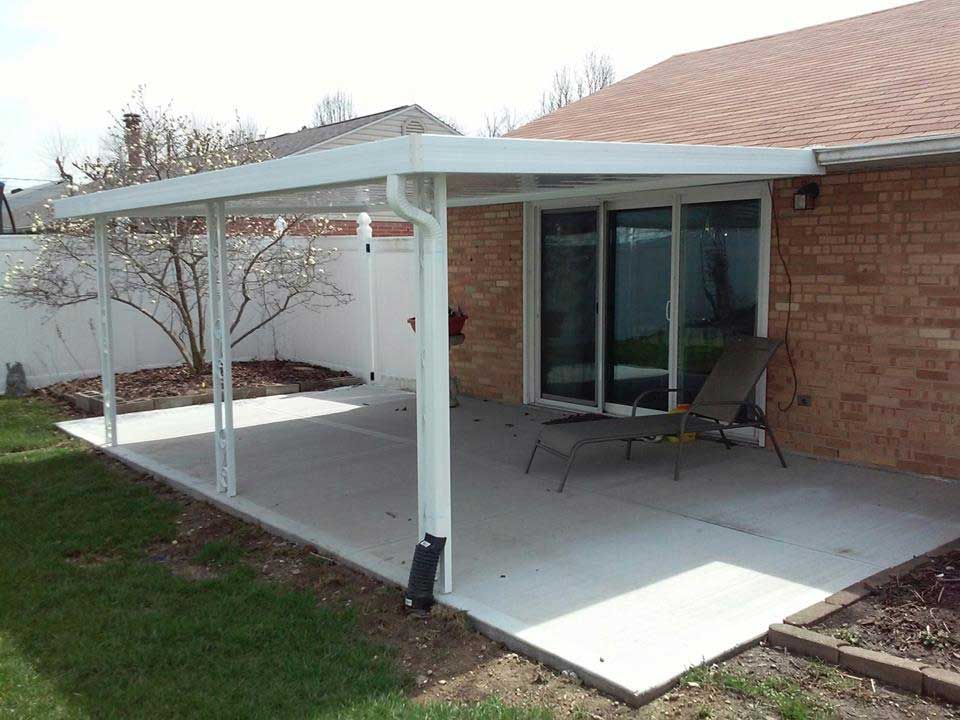 A patio with a sliding glass door and a chair underneath it.