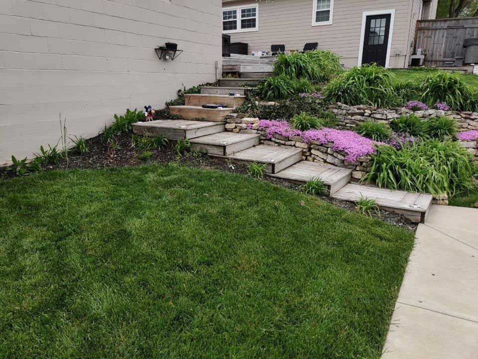 There are stairs leading up to the backyard of a house.