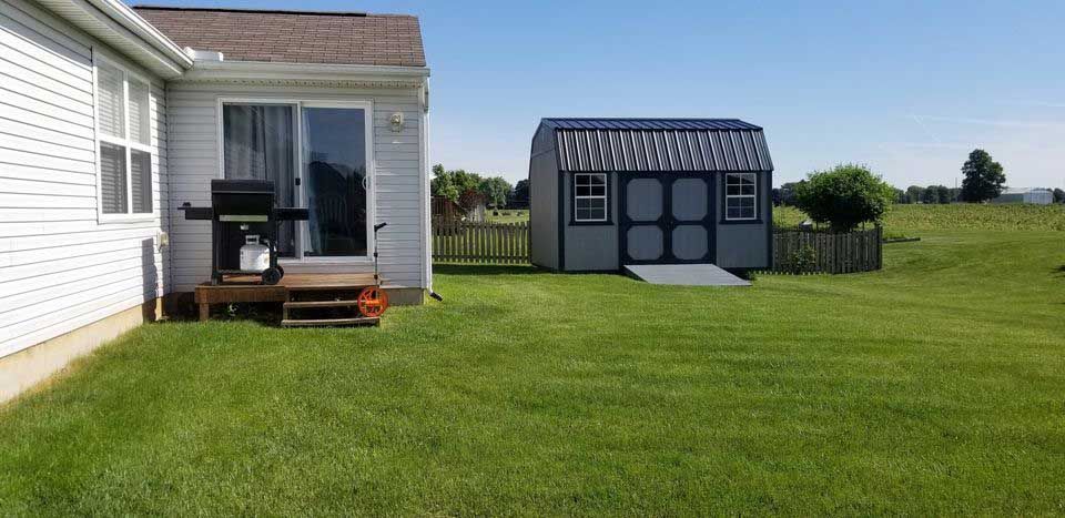 There is a shed in the backyard of a house.