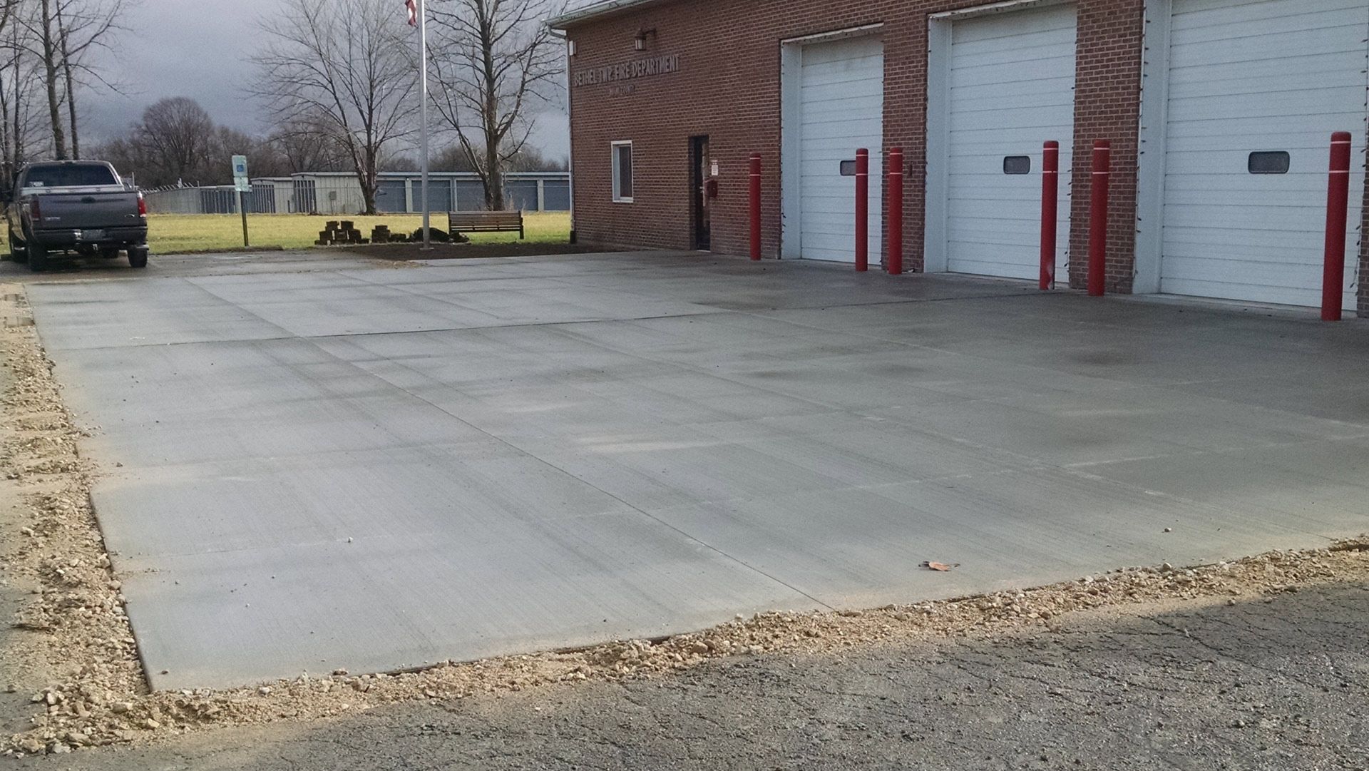A truck is parked in a parking lot in front of a garage.