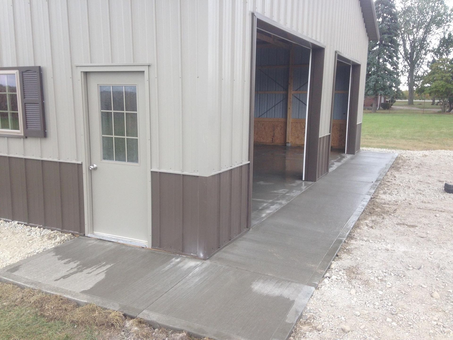 There is a concrete walkway leading to a garage door.