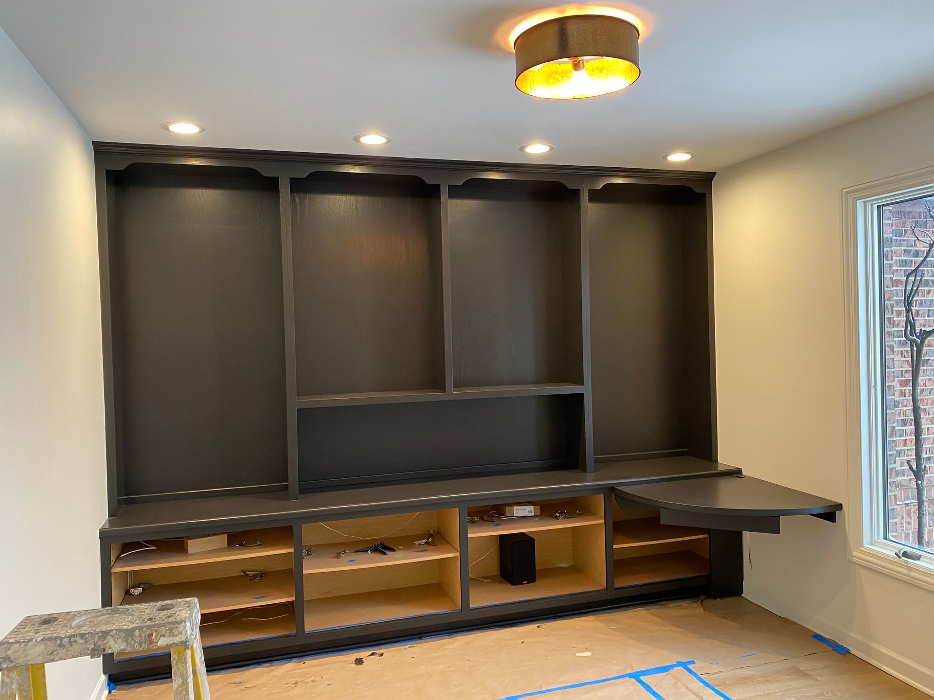 A room with a lot of shelves and a desk in it.