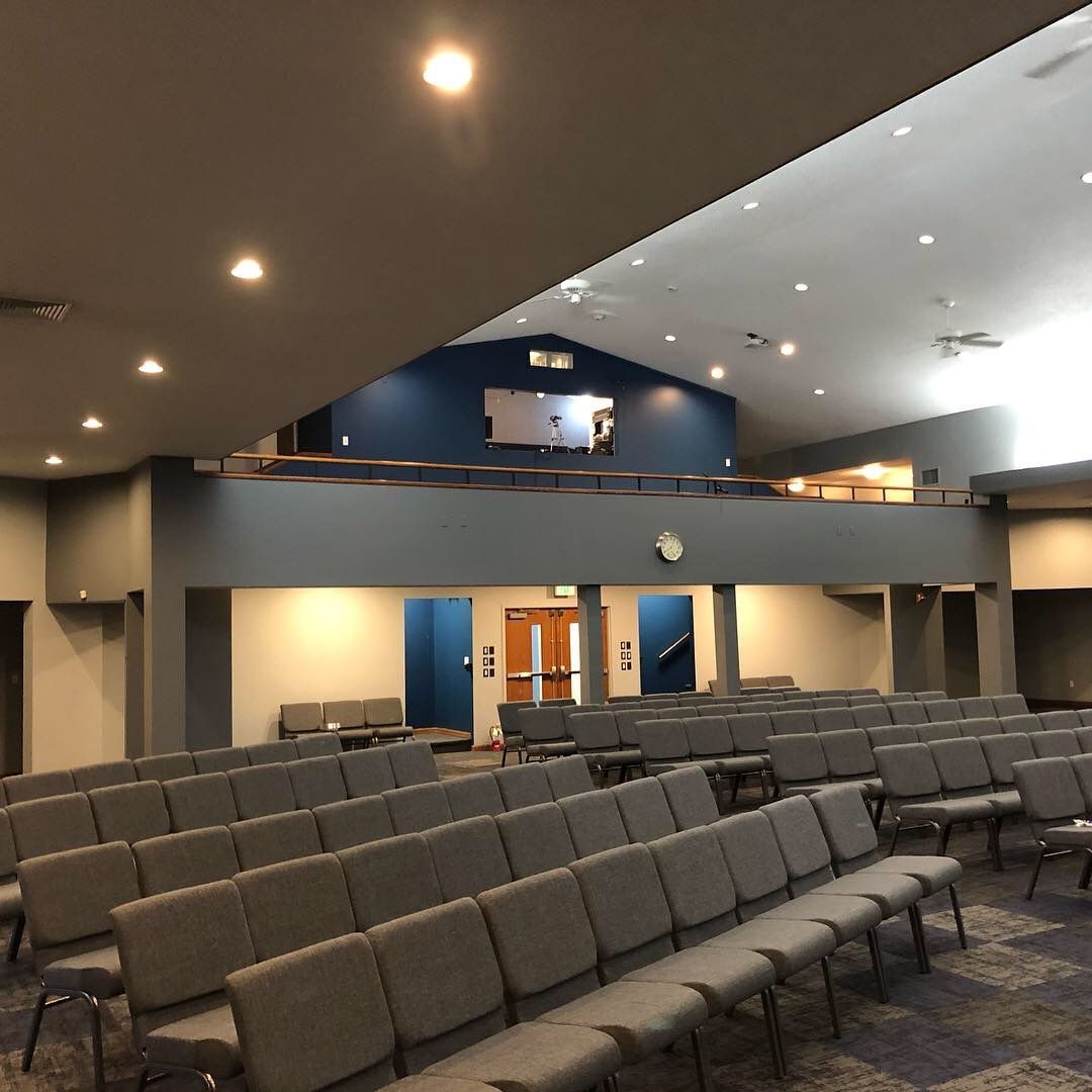 A large auditorium with rows of chairs and a balcony