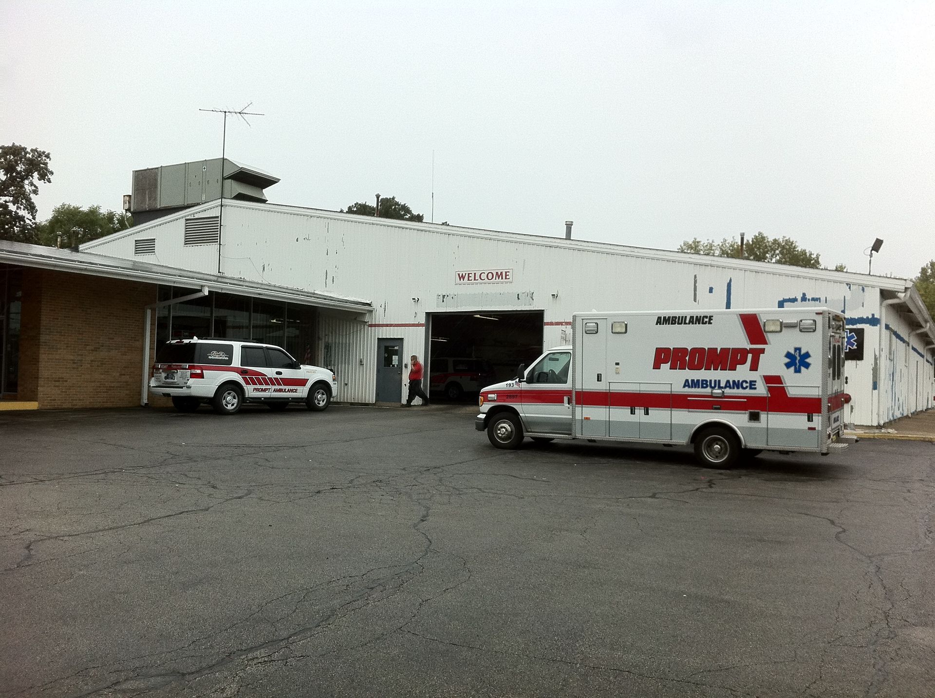 A prompt ambulance is parked in front of a building